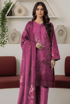 Woman wearing a pink embroidered outfit in a minimalistic room with decorative vases.