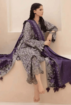 Woman sitting on a white couch wearing a floral dress and purple shawl.