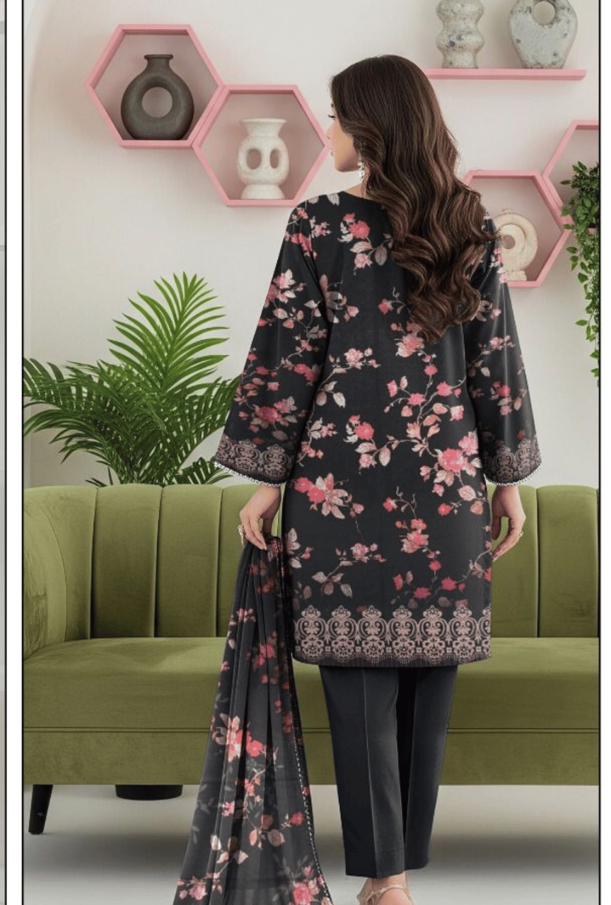 Woman wearing a floral dress with a matching scarf in a room with green sofa and decorative wall shelves.