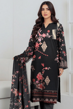 Woman wearing a black embroidered dress with floral patterns in a white room.