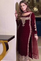 Woman wearing a maroon embroidered dress in an indoor setting