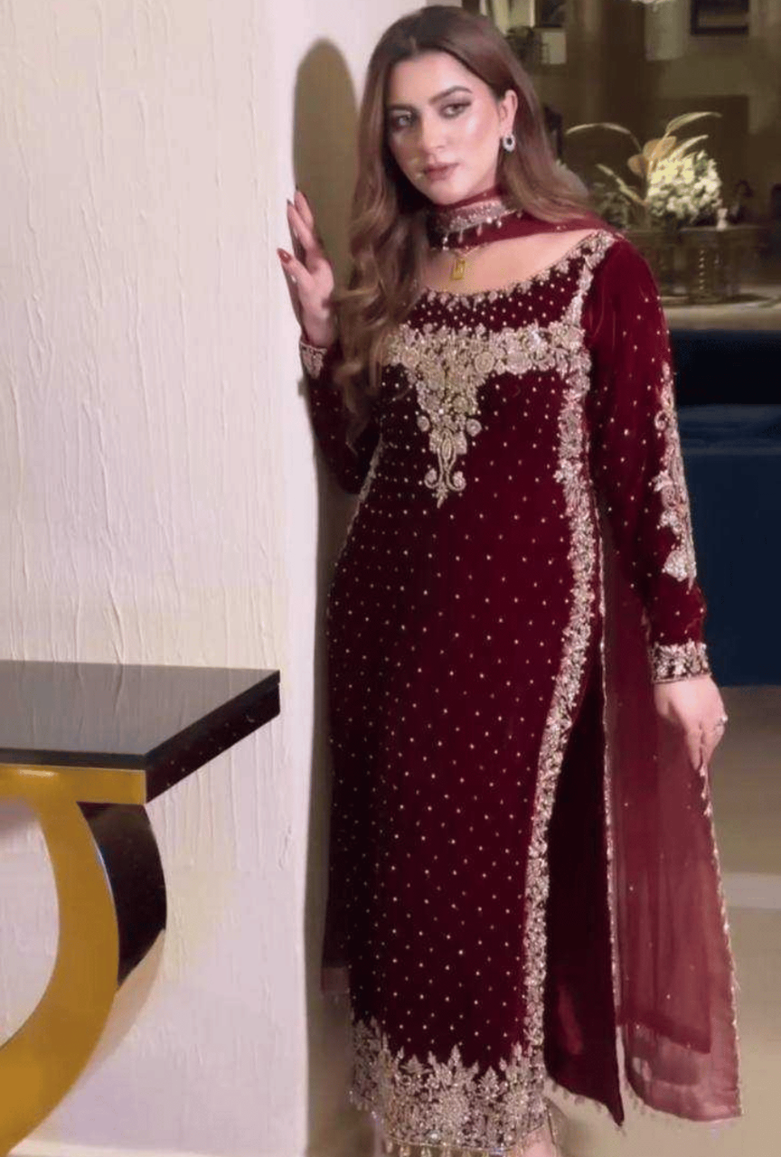 Woman wearing a maroon embroidered dress in an indoor setting