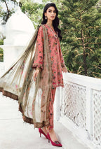 Woman in traditional pink and beige outfit with floral patterns, standing outdoors.