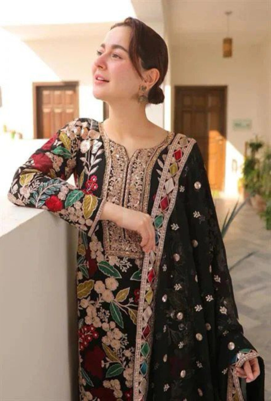 Woman wearing a floral embroidered outfit in an indoor setting