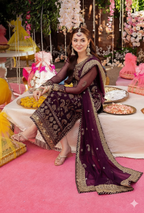 Woman in traditional attire at a festive indoor event with decorations and food.