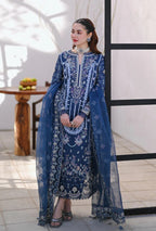 Woman wearing a blue embroidered traditional outfit with a matching dupatta in an outdoor setting.