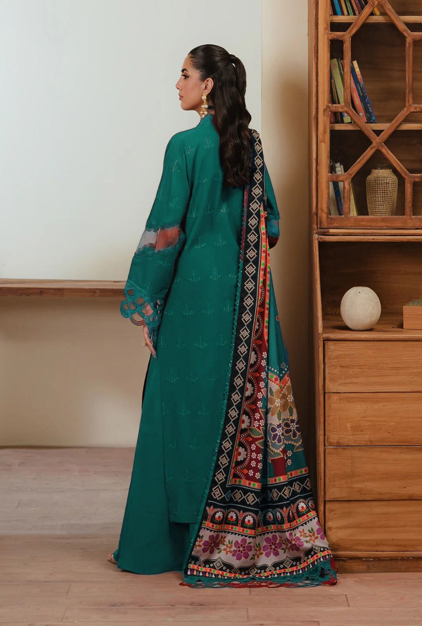 Woman in a teal traditional outfit with a patterned dupatta standing in a room.