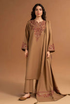 Woman wearing a beige embroidered traditional outfit on a brown background