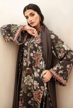 Woman wearing a floral dress with a matching dupatta against a plain background