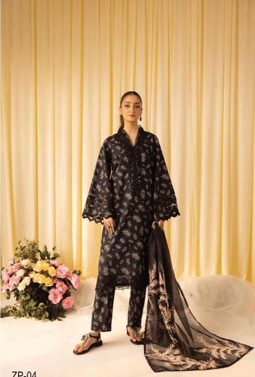 Woman wearing a black floral outfit with a sheer dupatta against a yellow curtain background