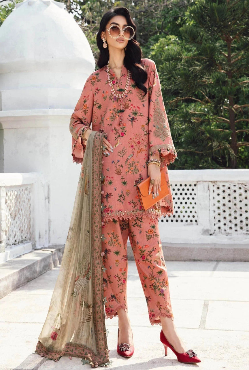 Woman in a pink floral outfit with a beige dupatta standing outdoors.