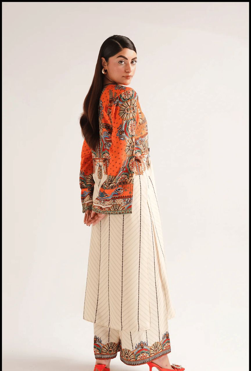 Woman wearing a traditional outfit with an orange and patterned top and white skirt on a plain background