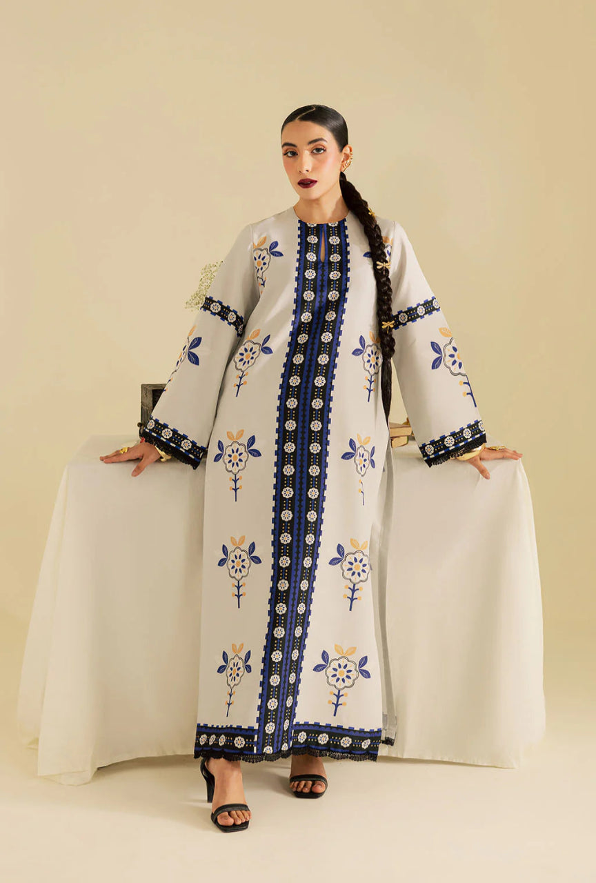 Woman wearing a long, embroidered dress with a neutral background