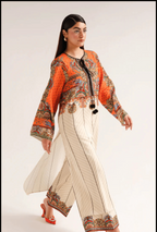 Woman wearing a traditional outfit with an orange top and white pants on a plain background