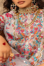 Close-up of a person wearing a colorful embroidered outfit with intricate jewelry.