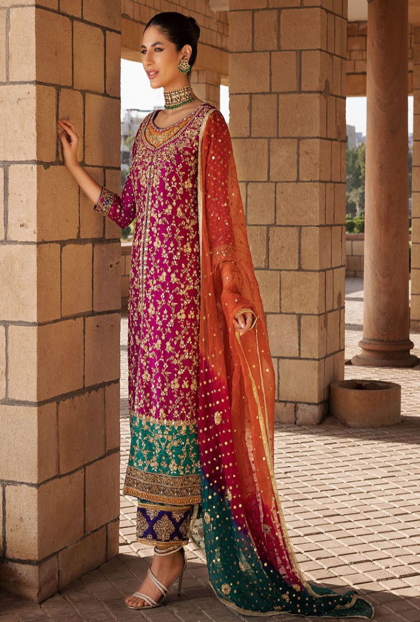 Woman in traditional embroidered outfit standing against a stone wall.