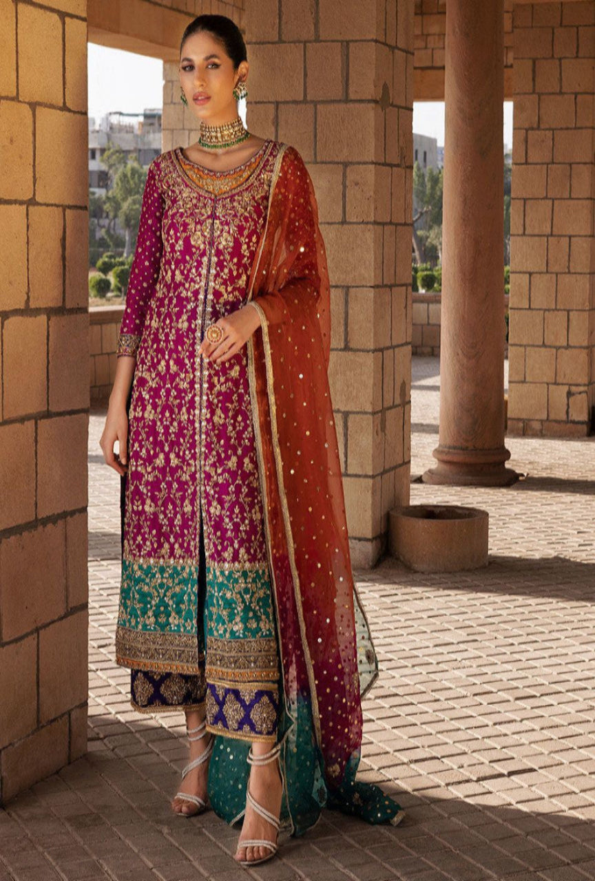 Woman in traditional embroidered outfit standing in a sunlit outdoor setting.