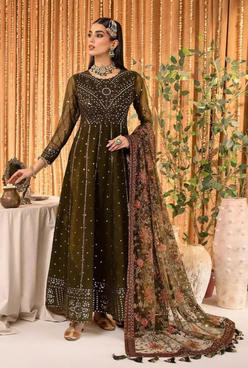 Woman in a black and gold traditional outfit with a floral dupatta against a decorative backdrop.