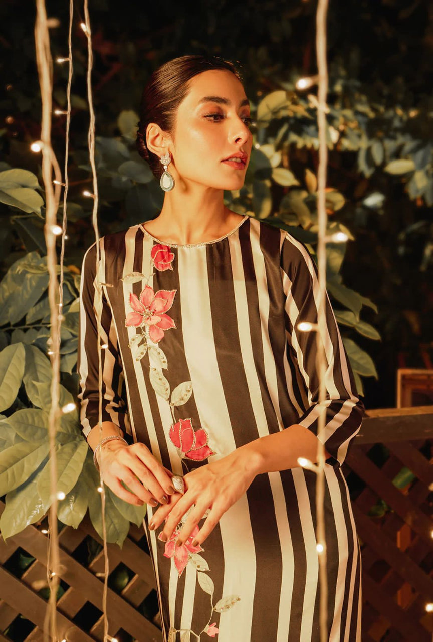 Woman wearing a striped dress with floral patterns in an outdoor setting