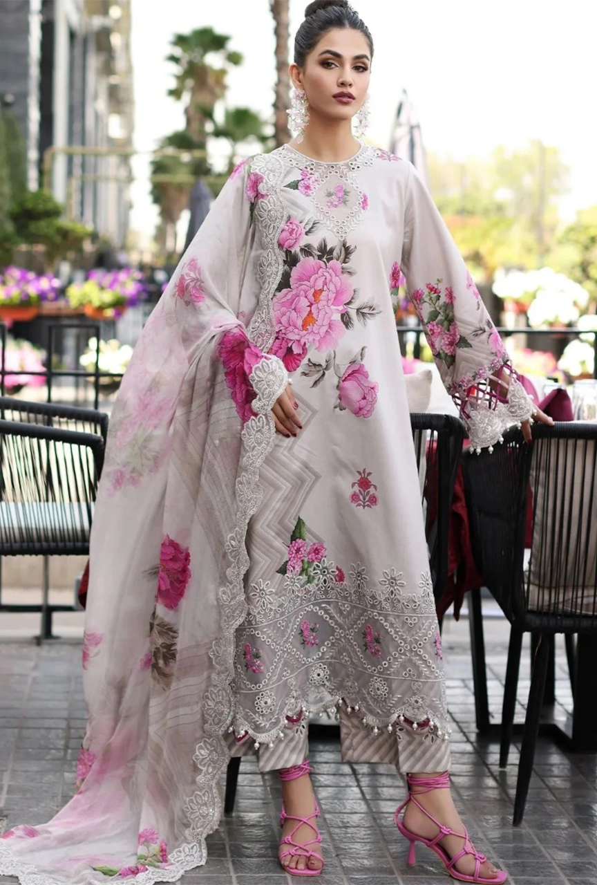 Woman in a floral embroidered outfit standing outdoors.