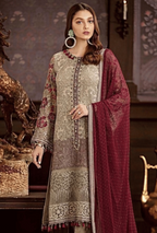 Woman wearing a traditional outfit with a maroon dupatta in an elegant setting.