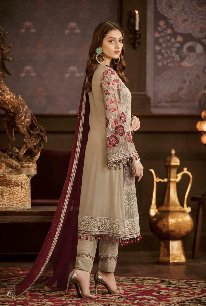 Woman in traditional outfit with embroidered top and matching dupatta in a decorative setting