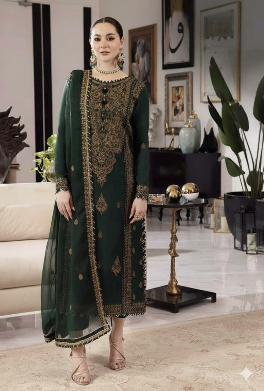 Woman in a green traditional outfit with gold embroidery in a stylish room.