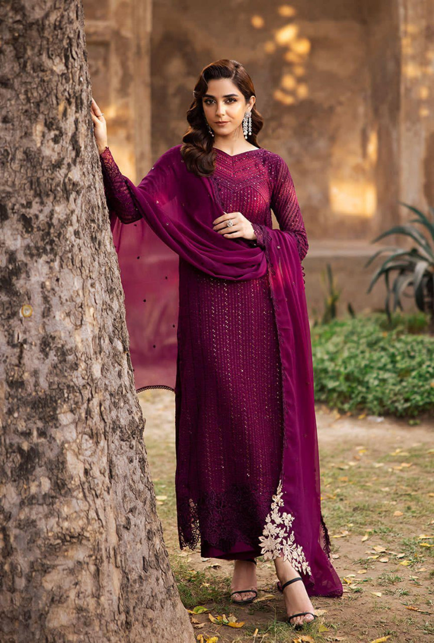Woman in a purple traditional outfit standing next to a tree