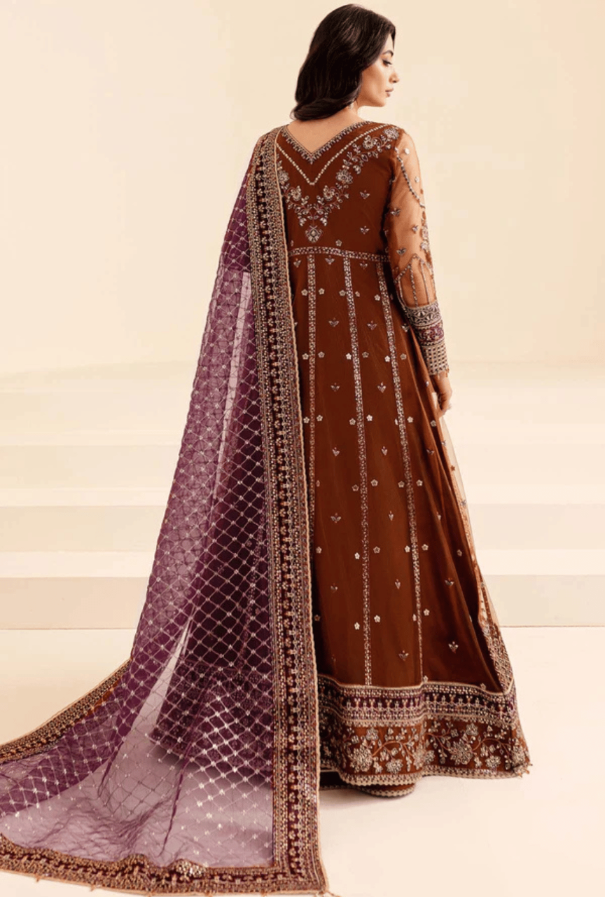 Woman wearing a brown embroidered outfit with a purple dupatta on a beige background