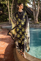 Woman in a floral dress standing by a pool with trees in the background