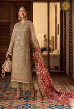 Woman in traditional embroidered outfit with a red dupatta in an indoor setting.