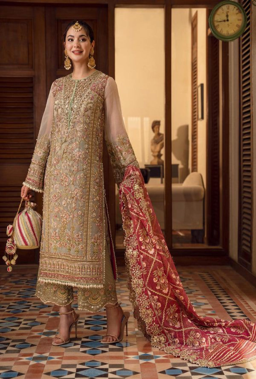 Woman in traditional embroidered outfit with a red dupatta in an indoor setting.