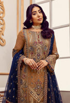 Woman wearing a traditional embroidered outfit with a blue dupatta in a well-lit room.