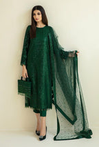 Woman wearing a green traditional outfit with a matching dupatta against a white background