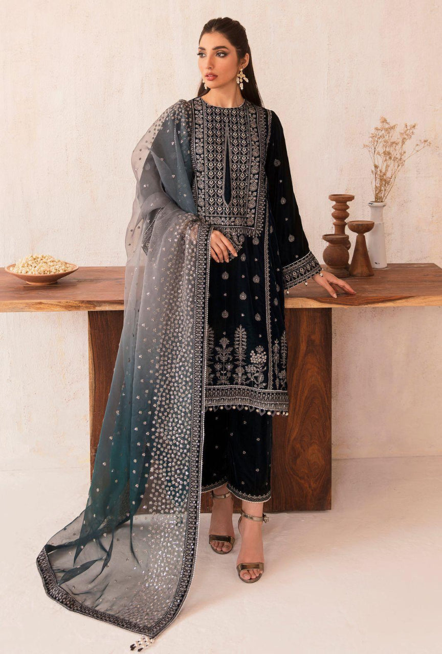 Woman in black embroidered outfit with a matching dupatta in a minimalistic setting