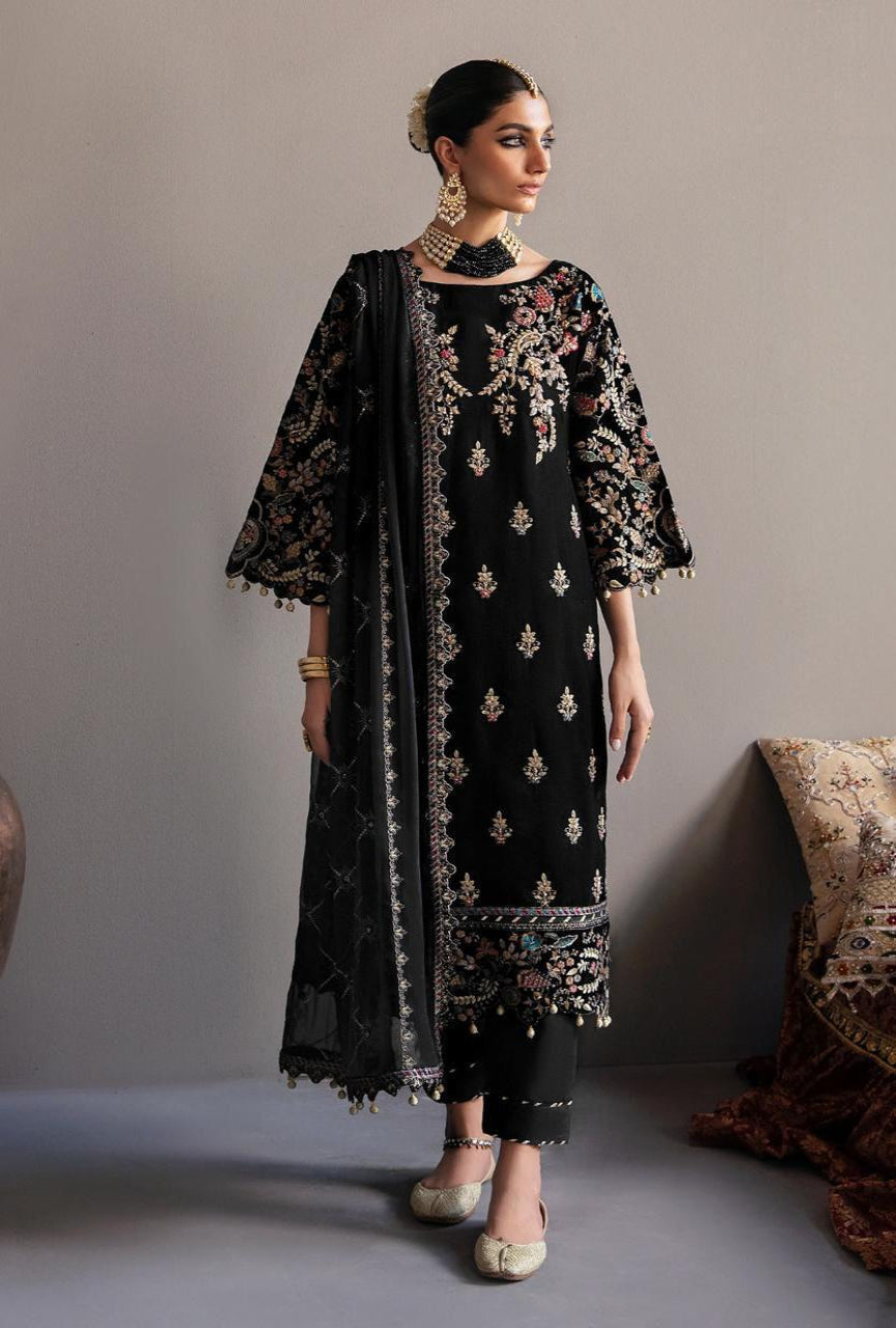Woman wearing a black embroidered outfit with a matching dupatta against a neutral background
