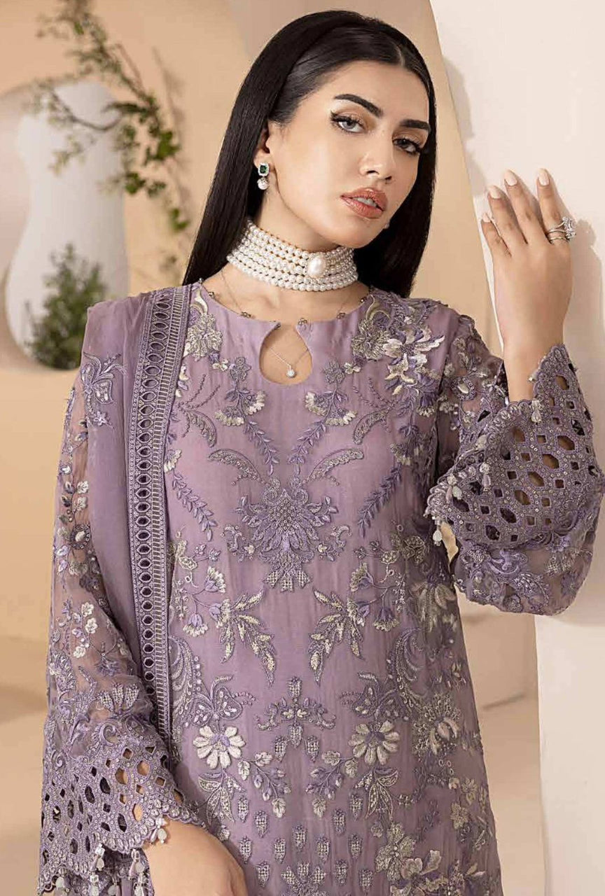 Woman wearing a purple embroidered outfit with a neutral background