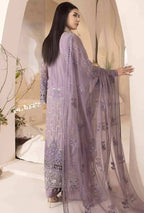 Woman wearing a light purple embroidered dupatta in a softly lit room.