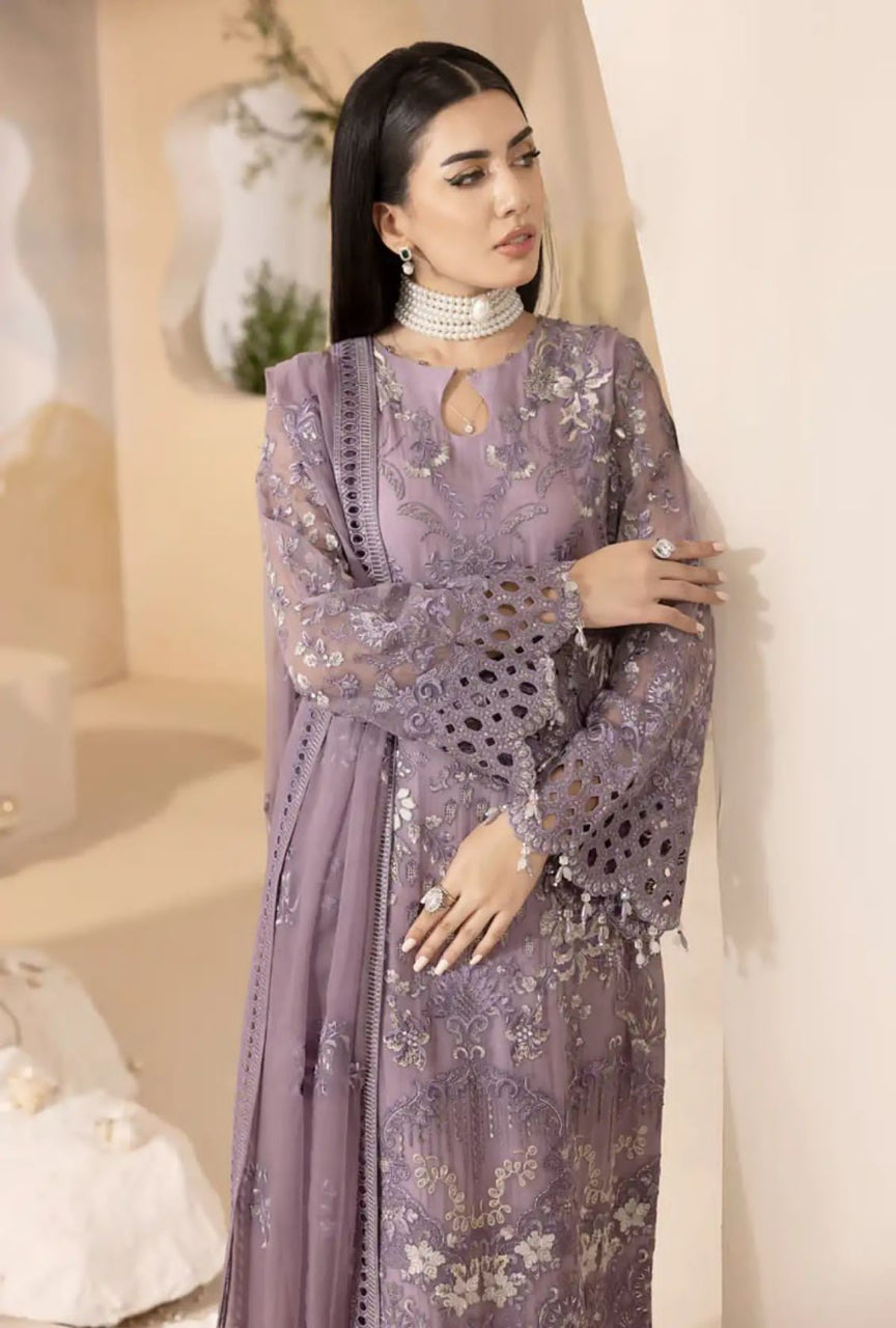 Woman wearing a purple embroidered outfit in an indoor setting