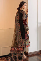 Woman wearing a traditional embroidered outfit in a room with a neutral color scheme.