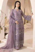 Woman wearing a lavender embroidered outfit in a decorated room.