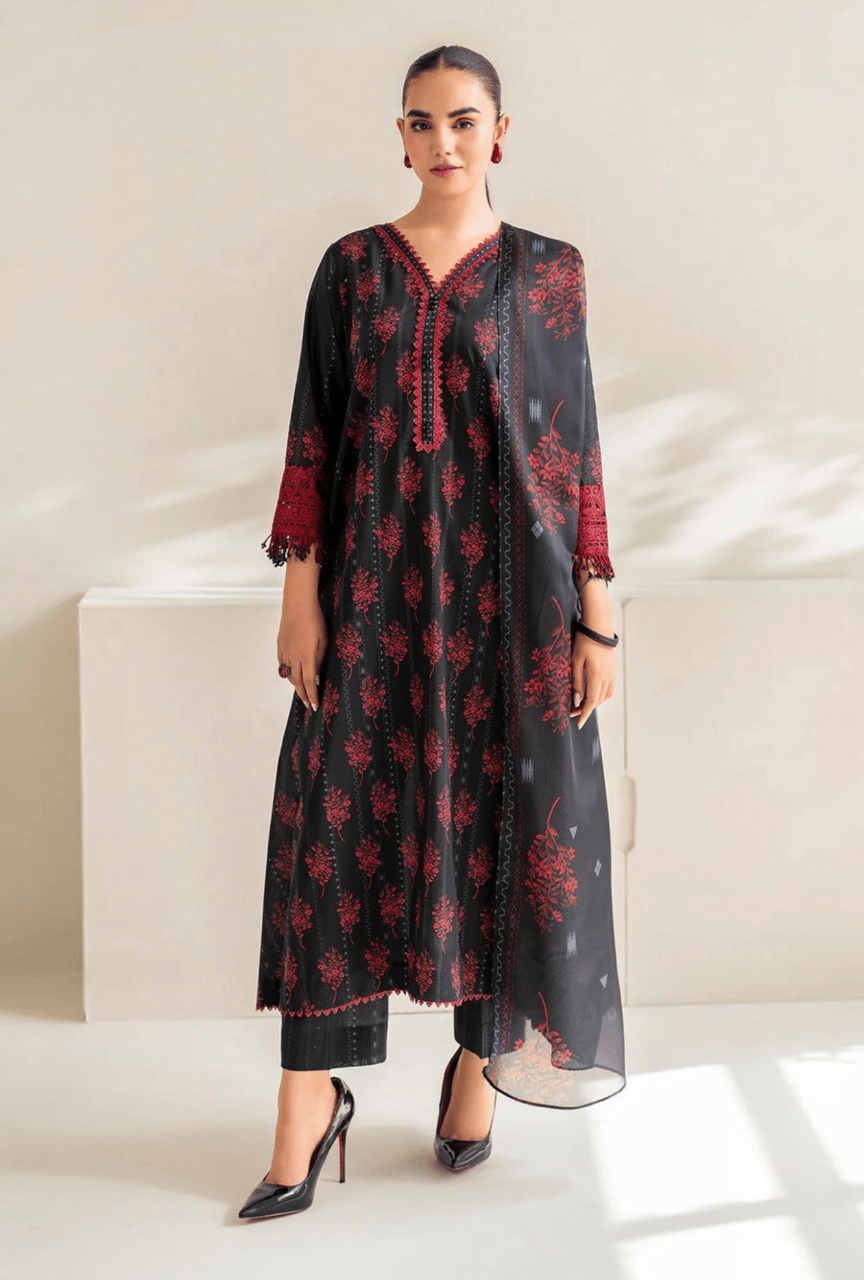 Woman wearing a black and red floral dress with a sheer dupatta in a minimalistic setting