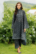 Woman wearing a dark gray embroidered traditional outfit in a garden setting