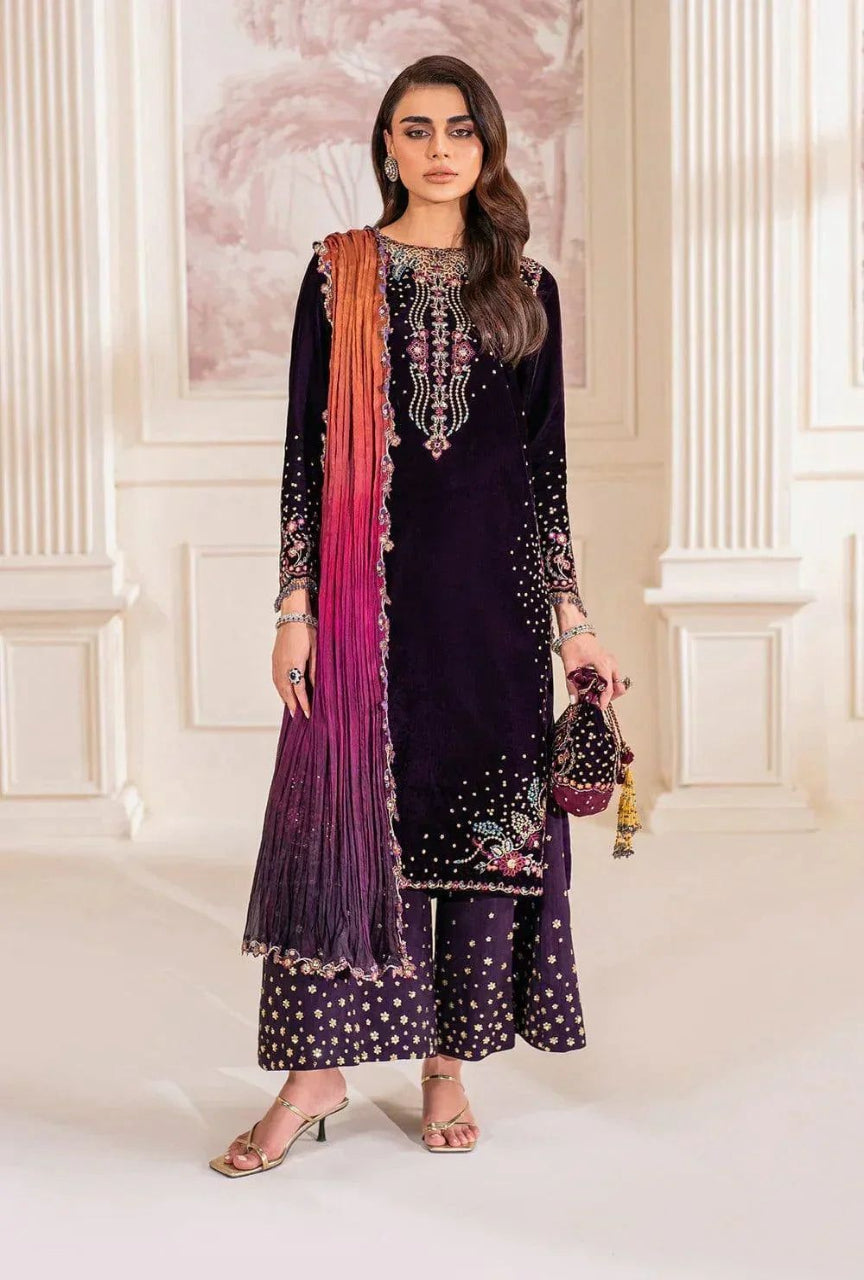 Woman in traditional outfit with purple dupatta and black embroidered dress in a decorative setting