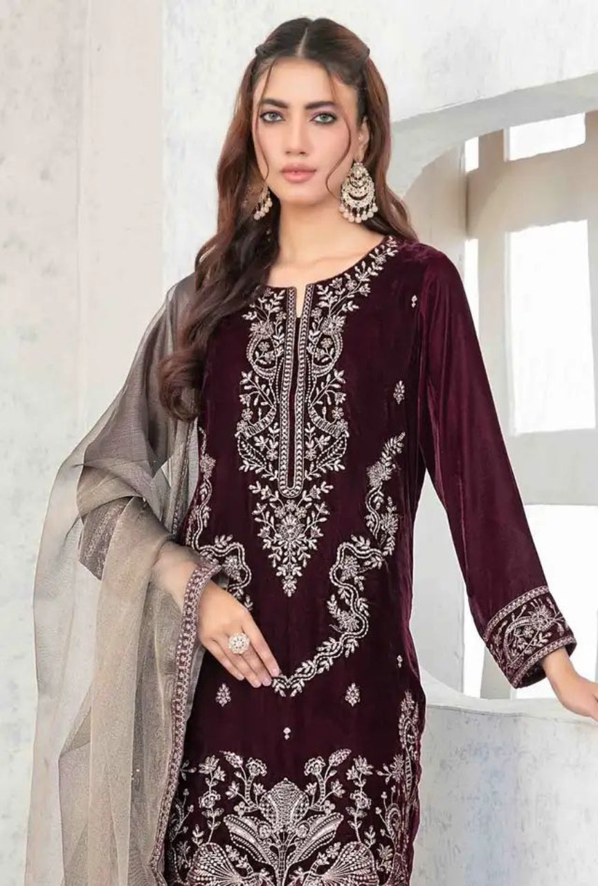 Woman wearing a maroon embroidered dress with a beige dupatta against a white background