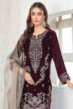 Woman wearing a maroon embroidered dress with a beige dupatta against a white background